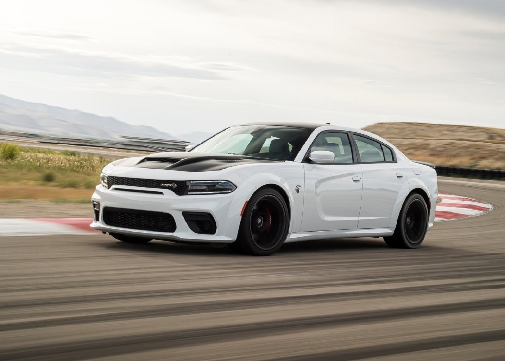 A white 2021 Dodge Charger SRT Hellcat Redeye drives on a racetrack