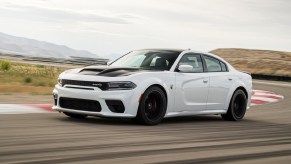 A white 2021 Dodge Charger SRT Hellcat Redeye drives on a racetrack