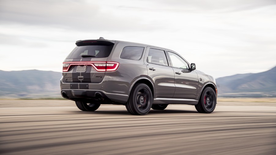 A silver and black 2021 Dodge Durango SRT Hellcat driving away from the camera on a dirt road