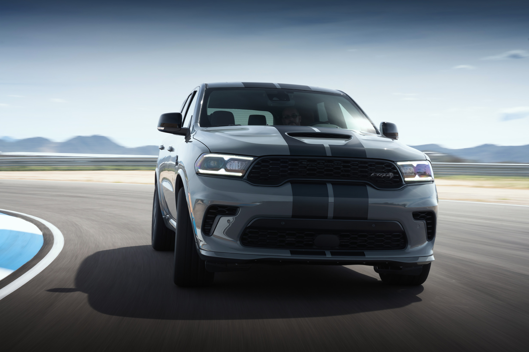 A silver and black 2021 Dodge Durango Hellcat driving on a track