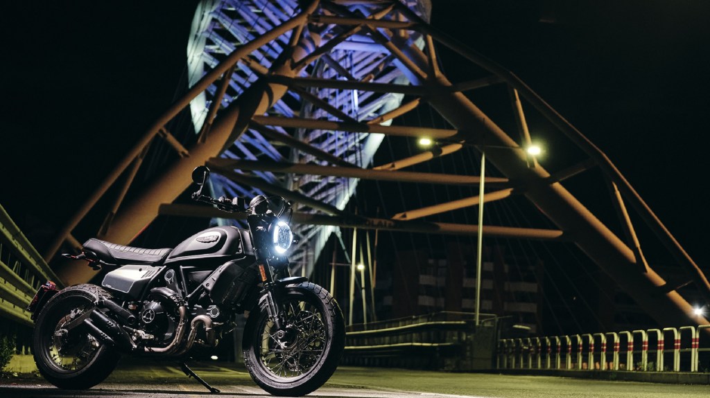 A gray 2021 Ducati Scrambler Nightshift on a bridge at night