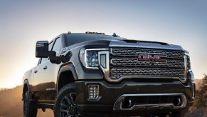 A 2021 GMC Sierra on blacktop with sunset behind it