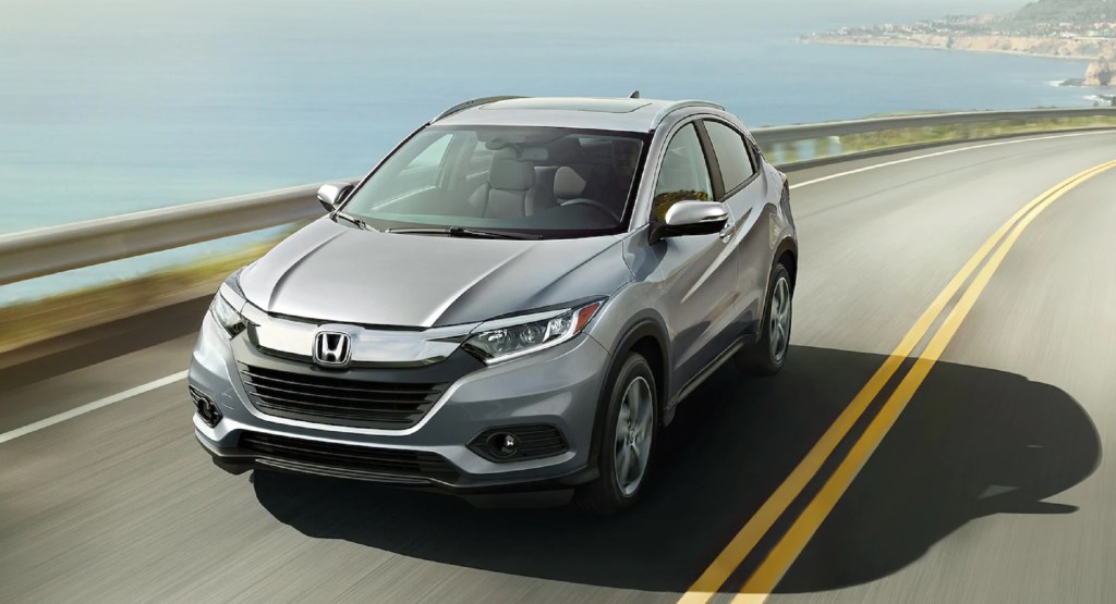 A silver 2021 Honda HR-V EX-L drives on an ocean-side road
