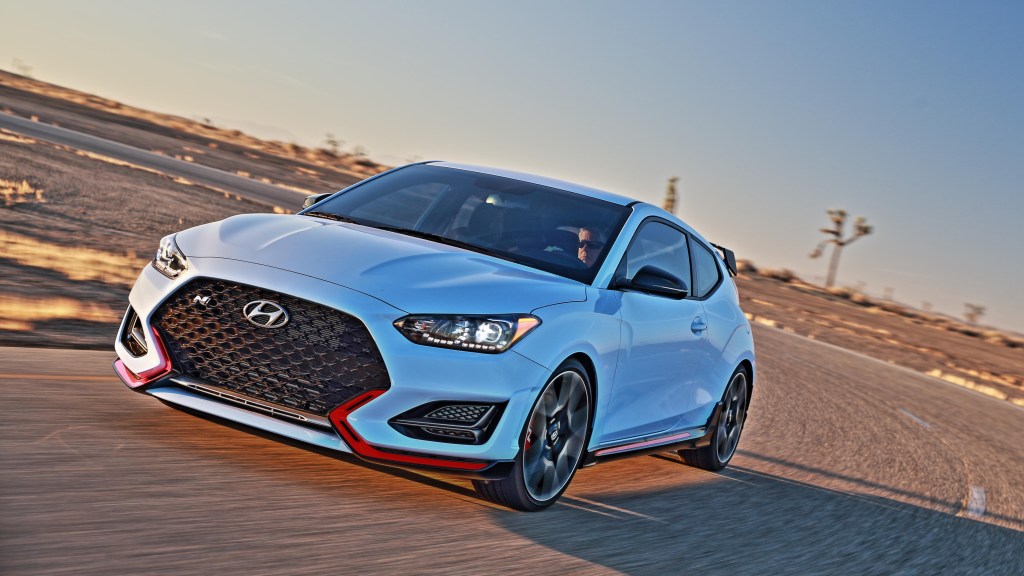 A white 2021 Hyundai Veloster N driving on a race track
