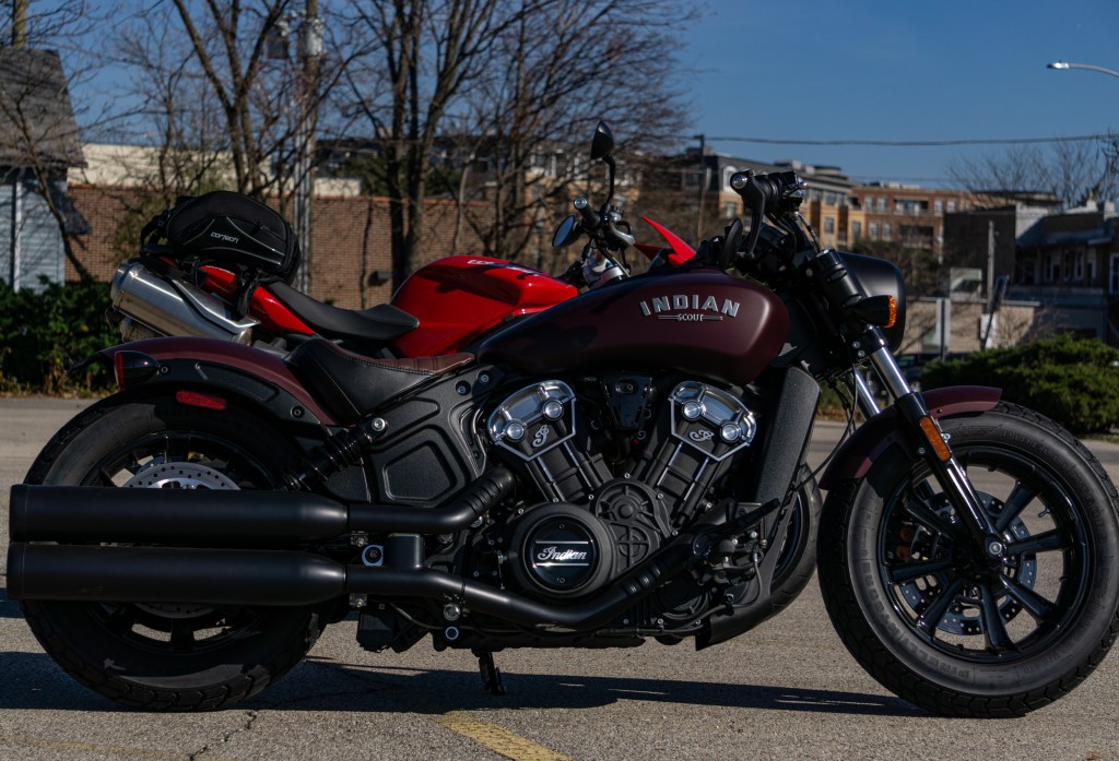 The side view of a maroon 2021 Indian Scout Bobber in front of a red 2012 Triumph Street Triple R