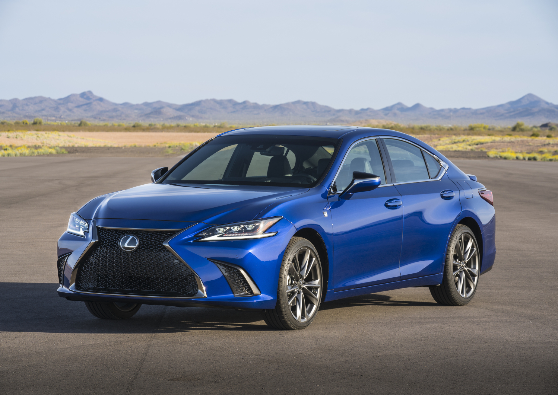 A blue 2021 Lexus ES on display with a mountain range in the background