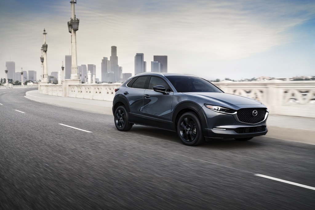 A silver 2021 Mazda CX-30 driving on a highway. It is one of the models Consumer Reports recommends for 2021.