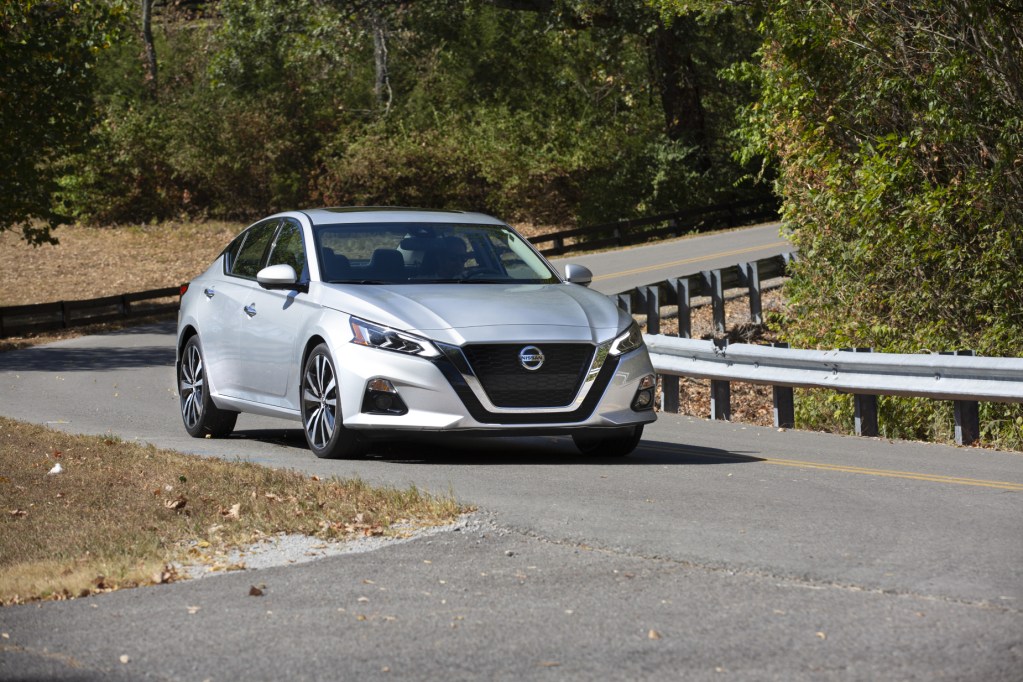 A silver 2021 Nissan Altima driving down a twisty road