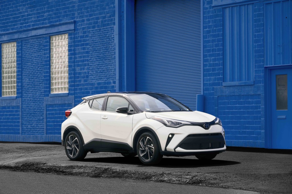 A white 2021 Toyota C-HR parked on display next to a blue wall