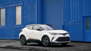 A white 2021 Toyota C-HR parked on display next to a blue wall