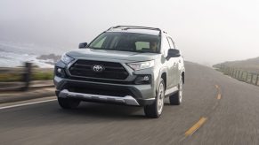 A silver 2021 Toyota RAV4 driving on a highway road