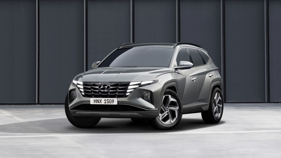 A grey 2022 Hyundai Tucson parked in front of a wall on display