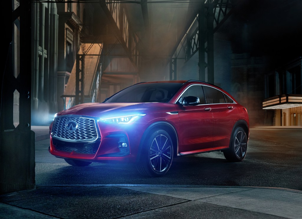 A red 2022 Infiniti QX55 parked on display in a dark alley