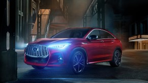 A red 2022 Infiniti QX55 parked on display in a dark alley