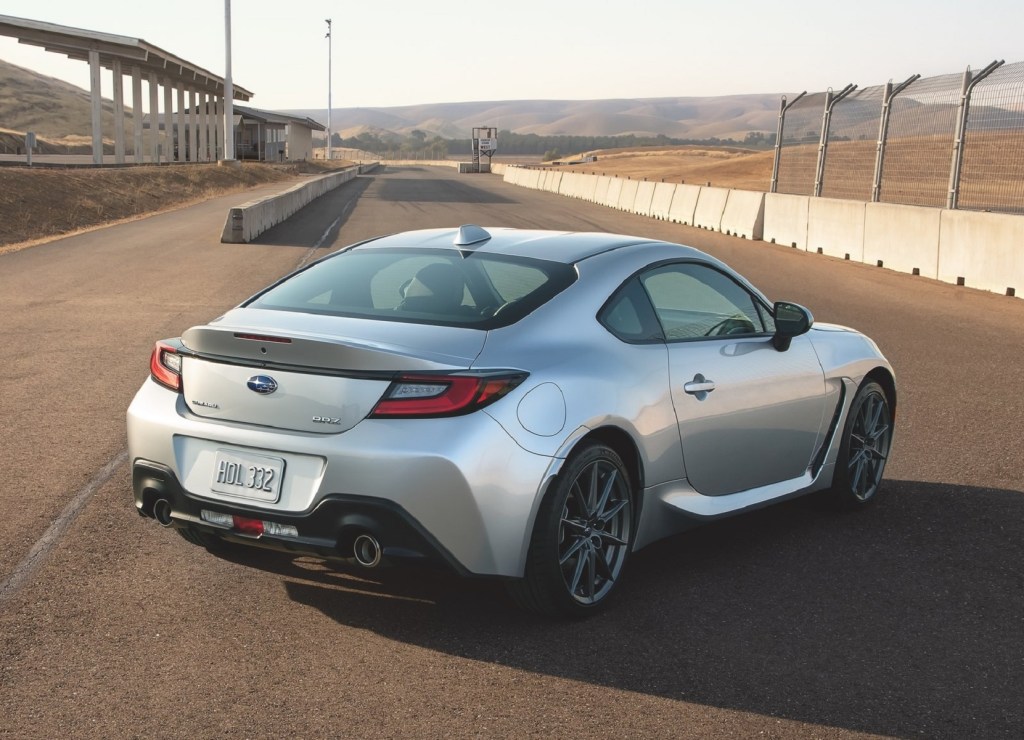 The rear 3/4 view of a silver 2022 Subaru BRZ on a racetrack