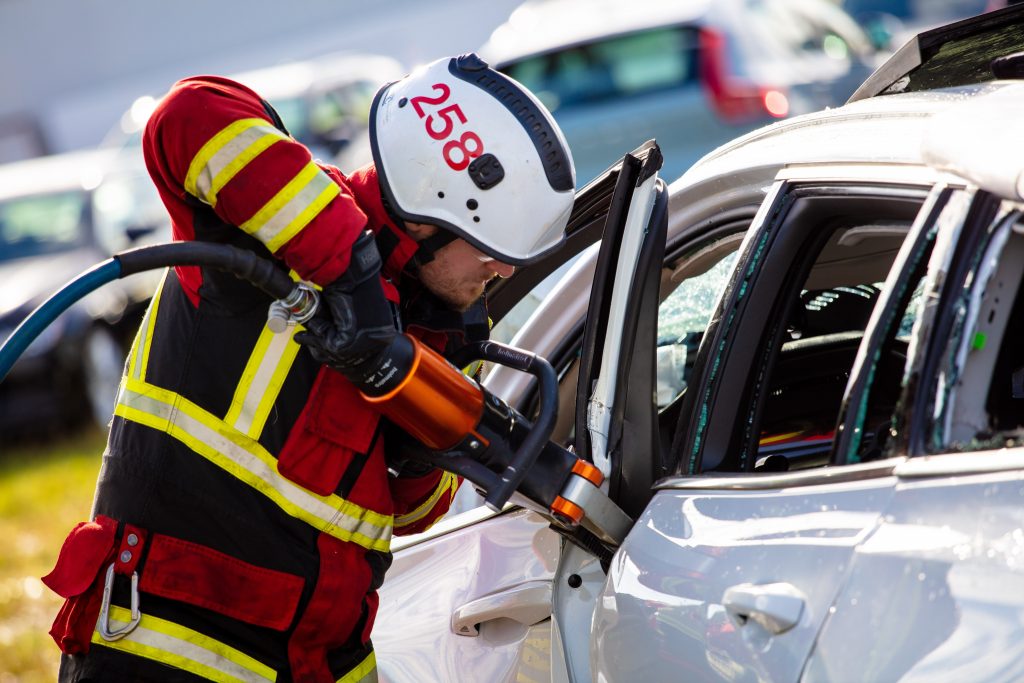 A safety training crew member uses the jaws of life on a Volvo.