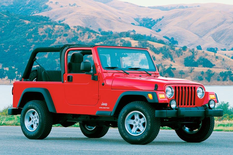 a red 2006 Jeep Wrangler with the top down parked against a mountainous backdrop. Some say older models like this one have fewer reliability issues. 
