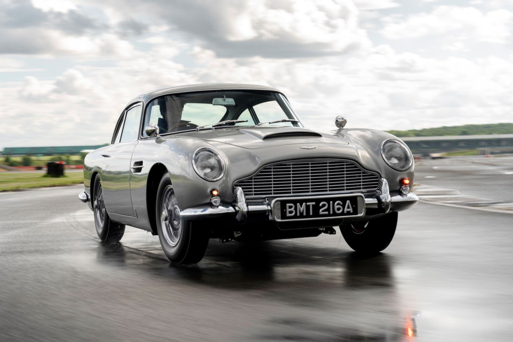 A silver Aston Martin 'Goldfinger' DB5 Continuation on a rainy track