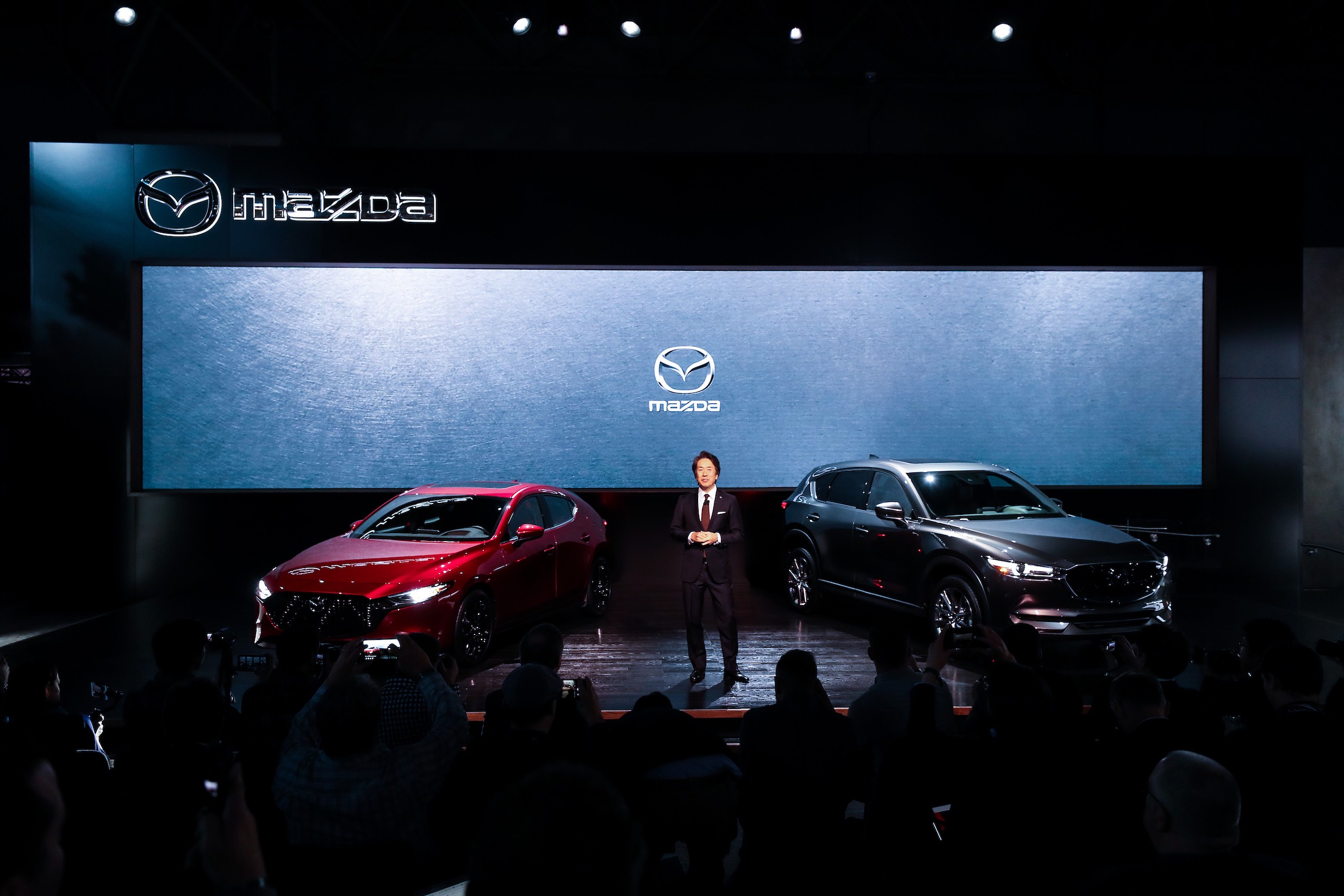 Masahiro Moro, Chairman and CEO of Mazda North American Operation presents 2020 Mazda 3 (L) and 2020 Mazda CX-5 (R) during the New York International Auto Show