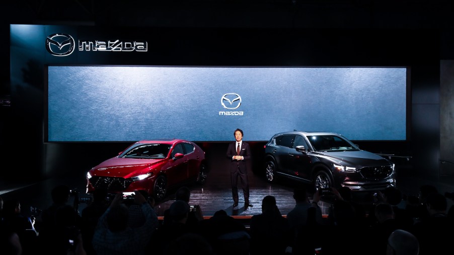 Masahiro Moro, Chairman and CEO of Mazda North American Operation presents 2020 Mazda 3 (L) and 2020 Mazda CX-5 (R) during the New York International Auto Show