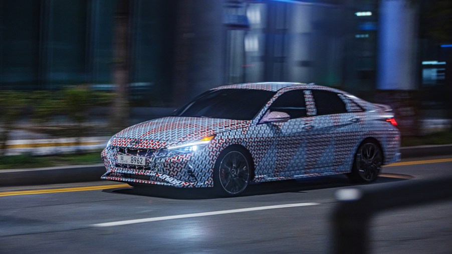 A camouflaged 2021 Hyundai Elantra N driving down a city street