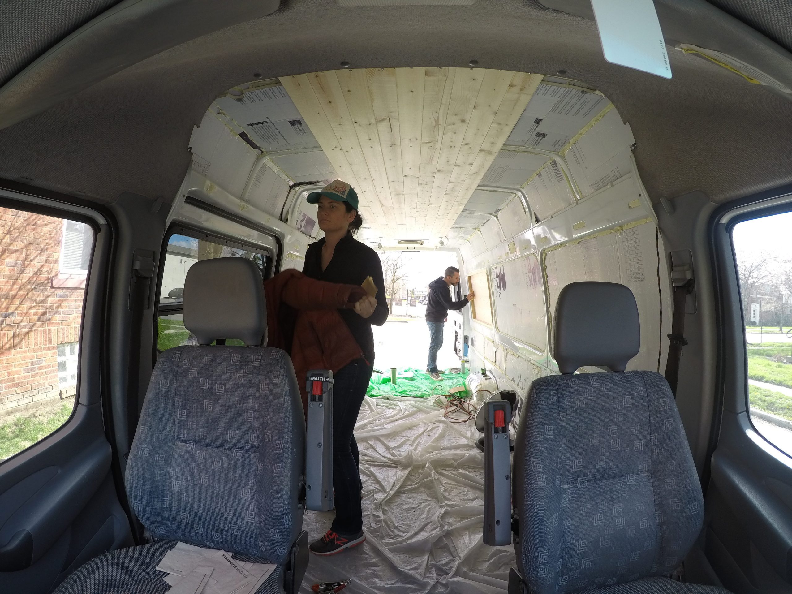 Two people work on converting a van into a camper