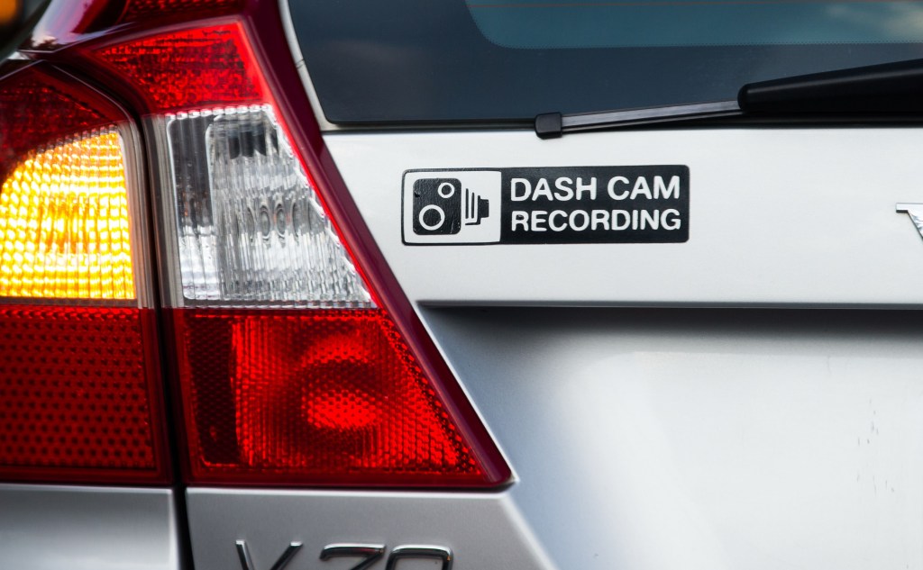 "Dashcam Recording" is written on the sticker stuck to a car