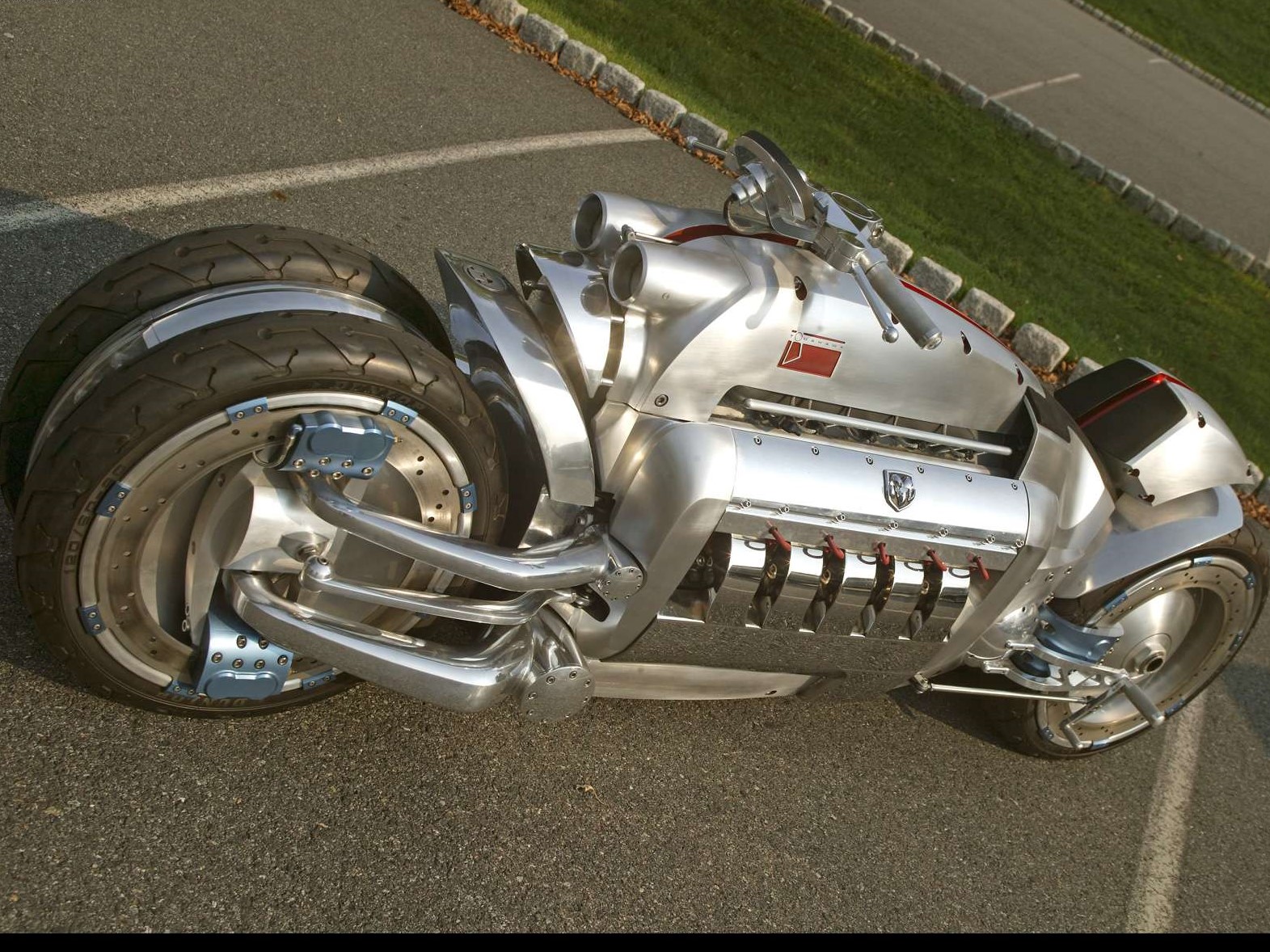 An aluminum bodied V10 powered motorcycle called the Dodge Tomahawk sits in a parking lot.