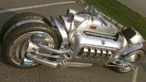 An aluminum bodied V10 powered motorcycle called the Dodge Tomahawk sits in a parking lot.