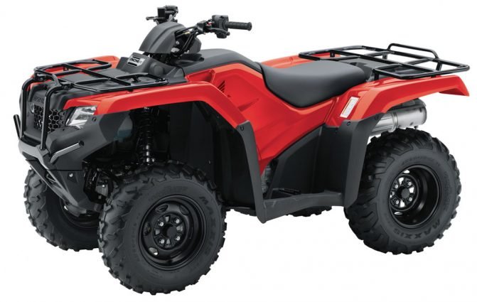 a red Honda FourTrax Rancher on display against a white backdrop