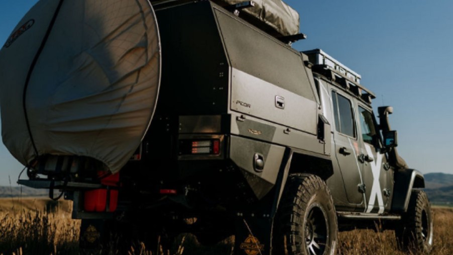 The rear 3/4 view of Expedition Overland's 2019 Jeep Gladiator in a field