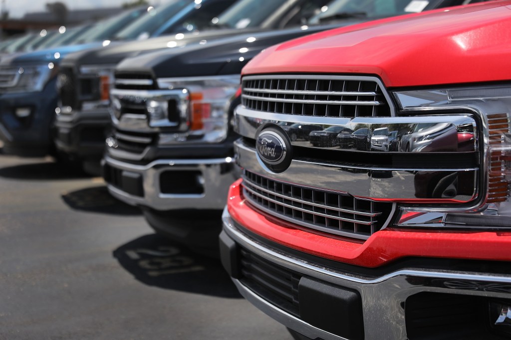Ford trucks are seen on a sales lot, with close-ups of the grilles