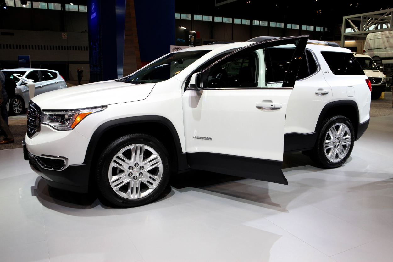 A white GMC Acadia on display at an auto show
