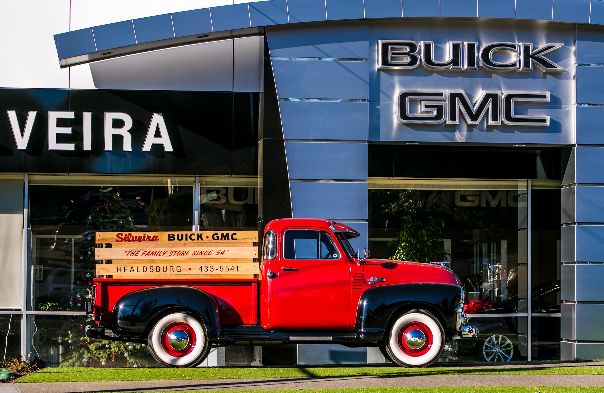 Vintage Truck in front of GMC dealership Hummer EV