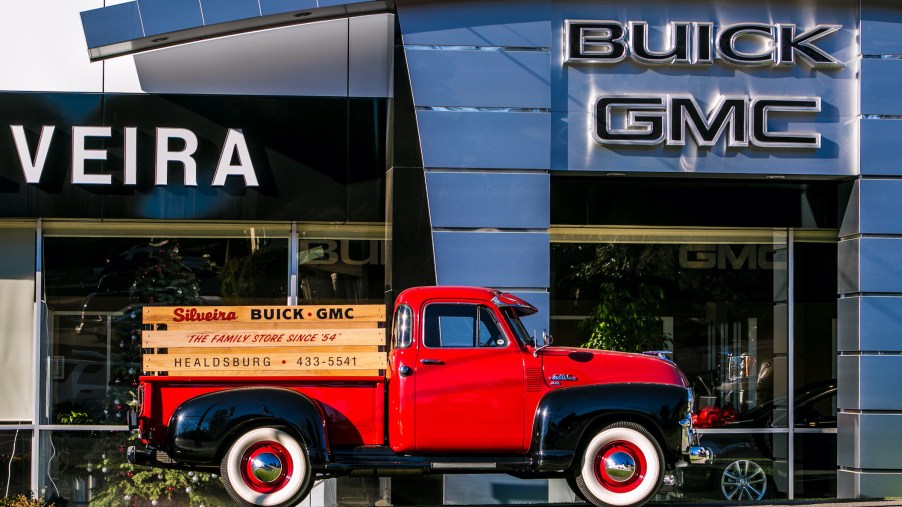 Vintage Truck in front of GMC dealership Hummer EV