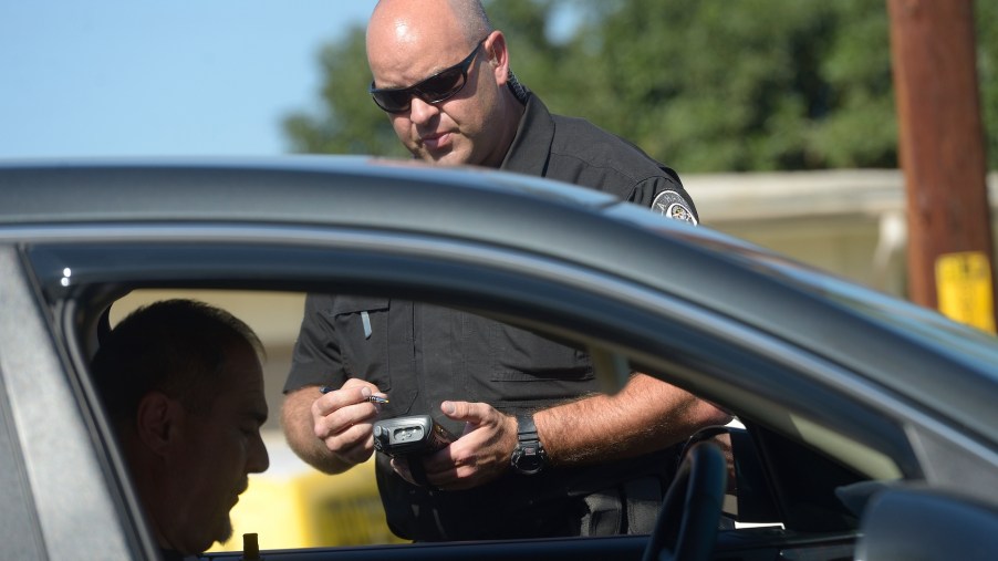 An image of a police officer handing out a speeding ticket.