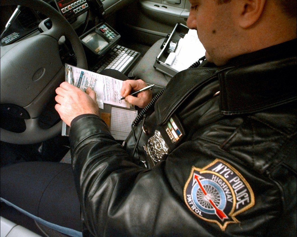 An image of a police officer handing out a speeding ticket.