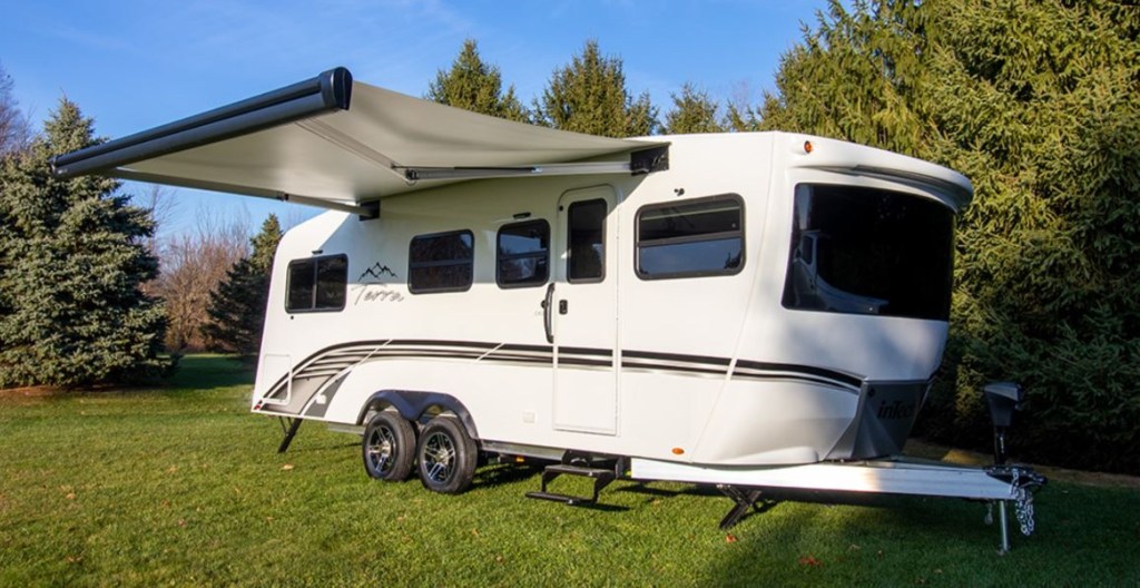 A white 2021 Terra Oasis travel trailer RV has the awning extended. 