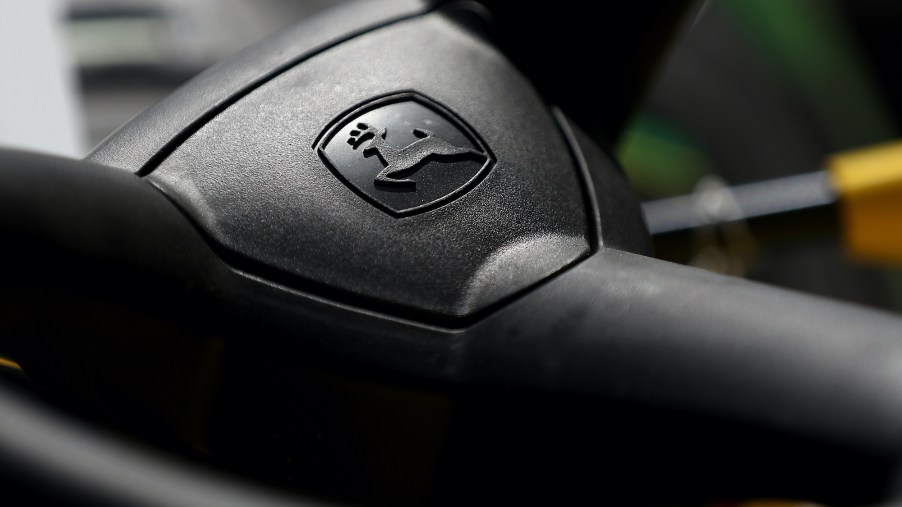 The John Deere logo is seen on a riding mower steering wheel