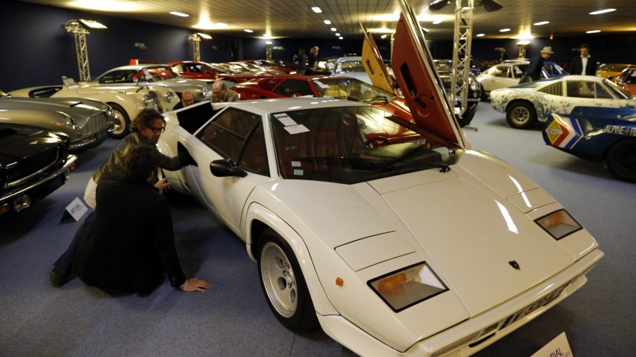 A white Lamborghini Countach is on display at an indoor show.