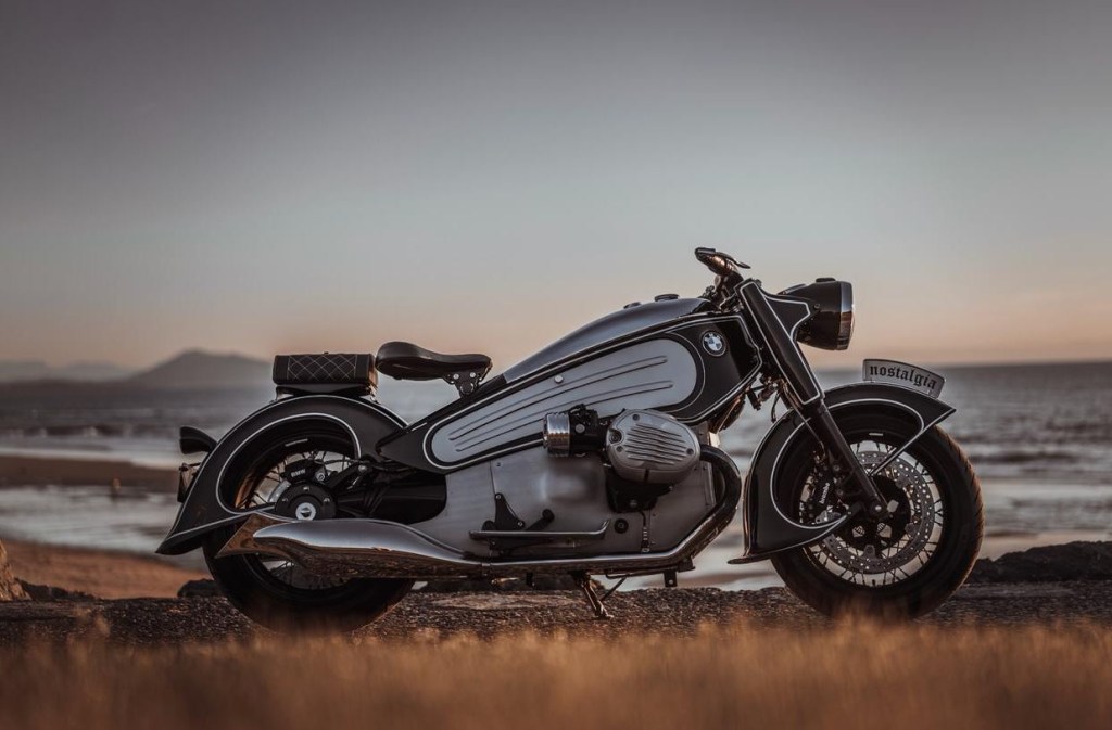 A black and white custom, hand made motorcycle against a backdrop of dusk.