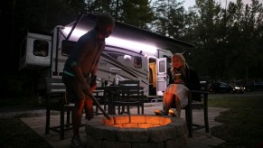 Christian Arriola and Washington Post travel writer Andrea Sachs sit around a fire outside of their rented RV Saturday, September 19, 2020 at a KOA campground