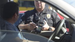 La Habra police officer Jason Coleman issues a speeding citation using a e-citation machine on Monday.