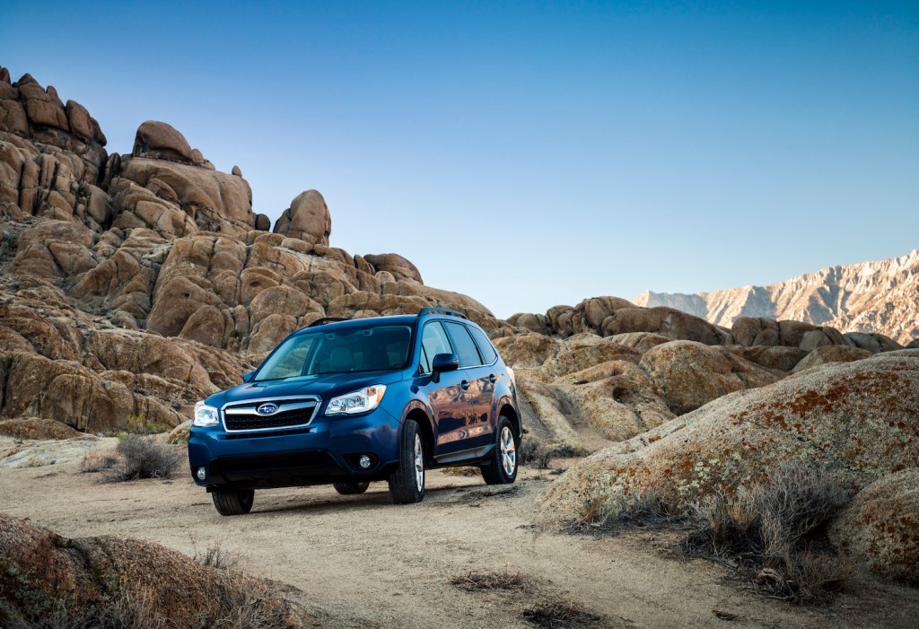 A Subaru Forester crossover SUV driving down a dirt road