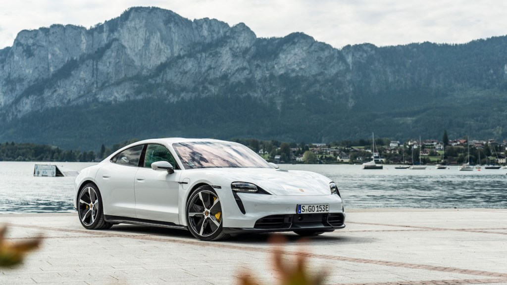 A photo of the Porsche Taycan outdoors by a lake.