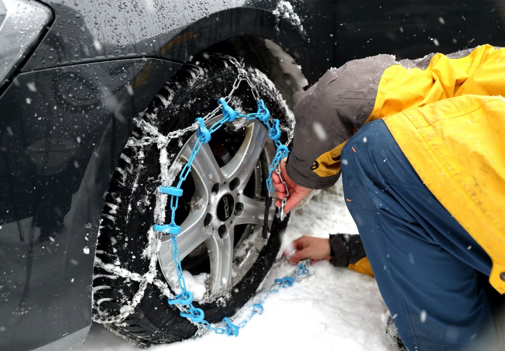 man installing tire chains