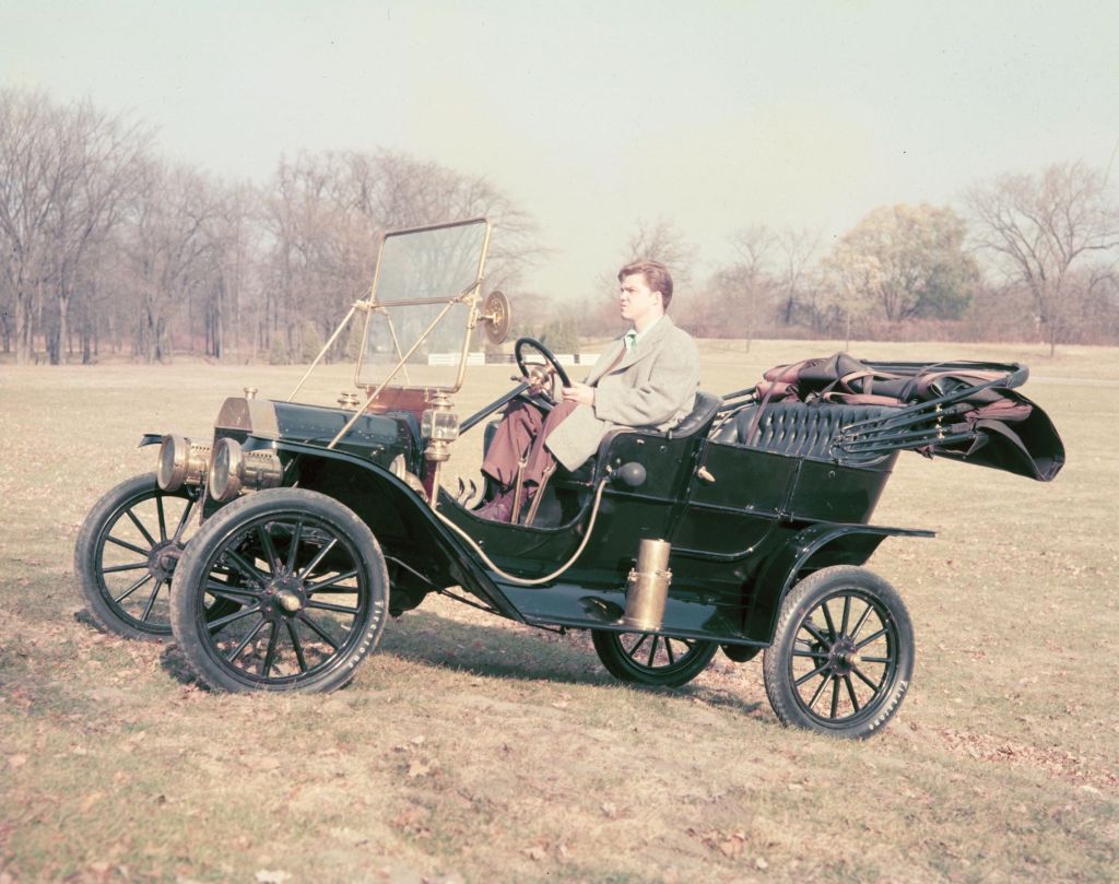 A black 1908 Ford Model T in a field