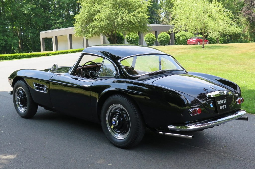 The rear 3/4 view of a black 1957 BMW 507 Series II with its hardtop on