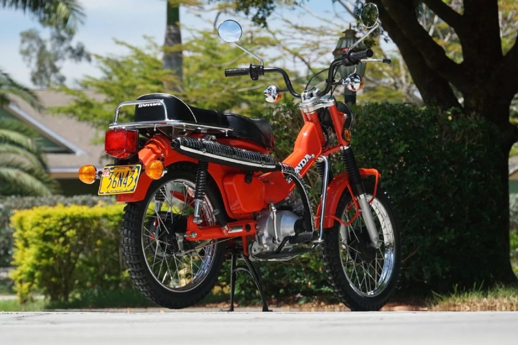 The rear 3/4 view of an orange 1979 Honda CT90 Trail 90