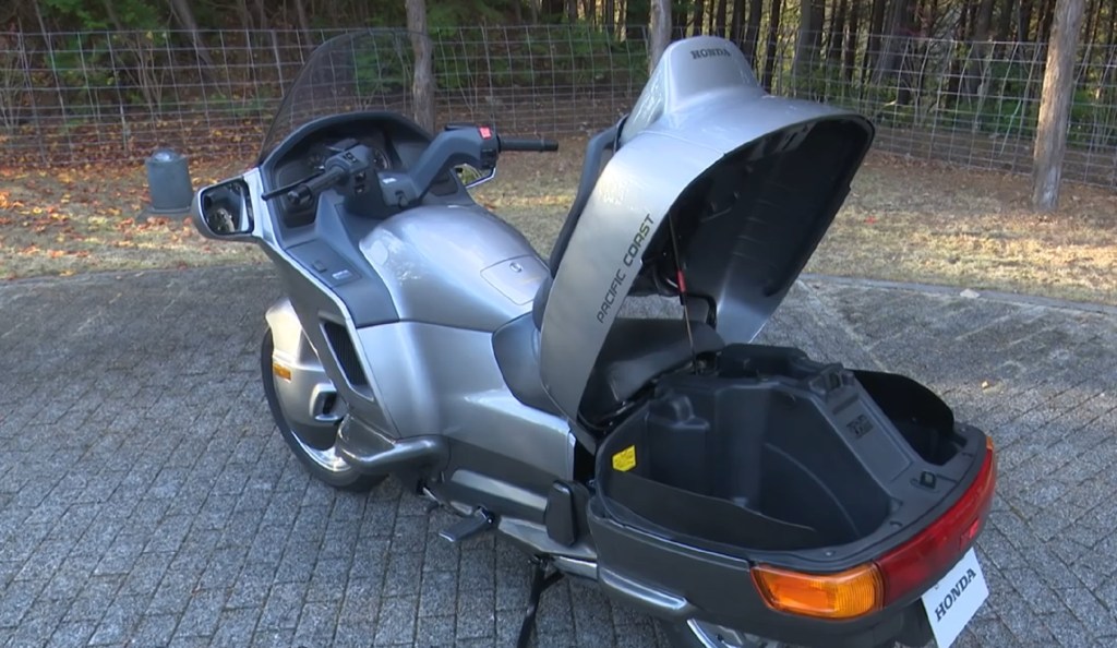 The rear 3/4 view of a gray 1990 Honda PC800 Pacific Coast with its trunk open